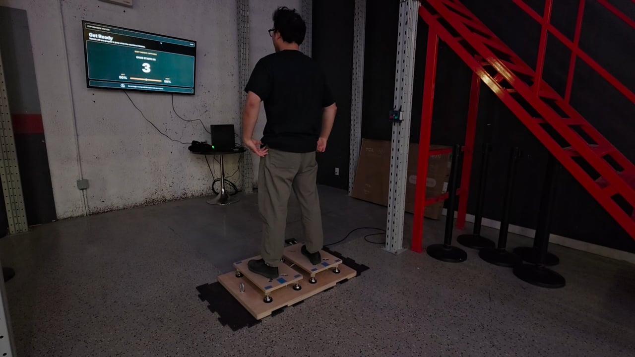 A participant standing on the dual force plates in front of the game display at Breathe Parkour